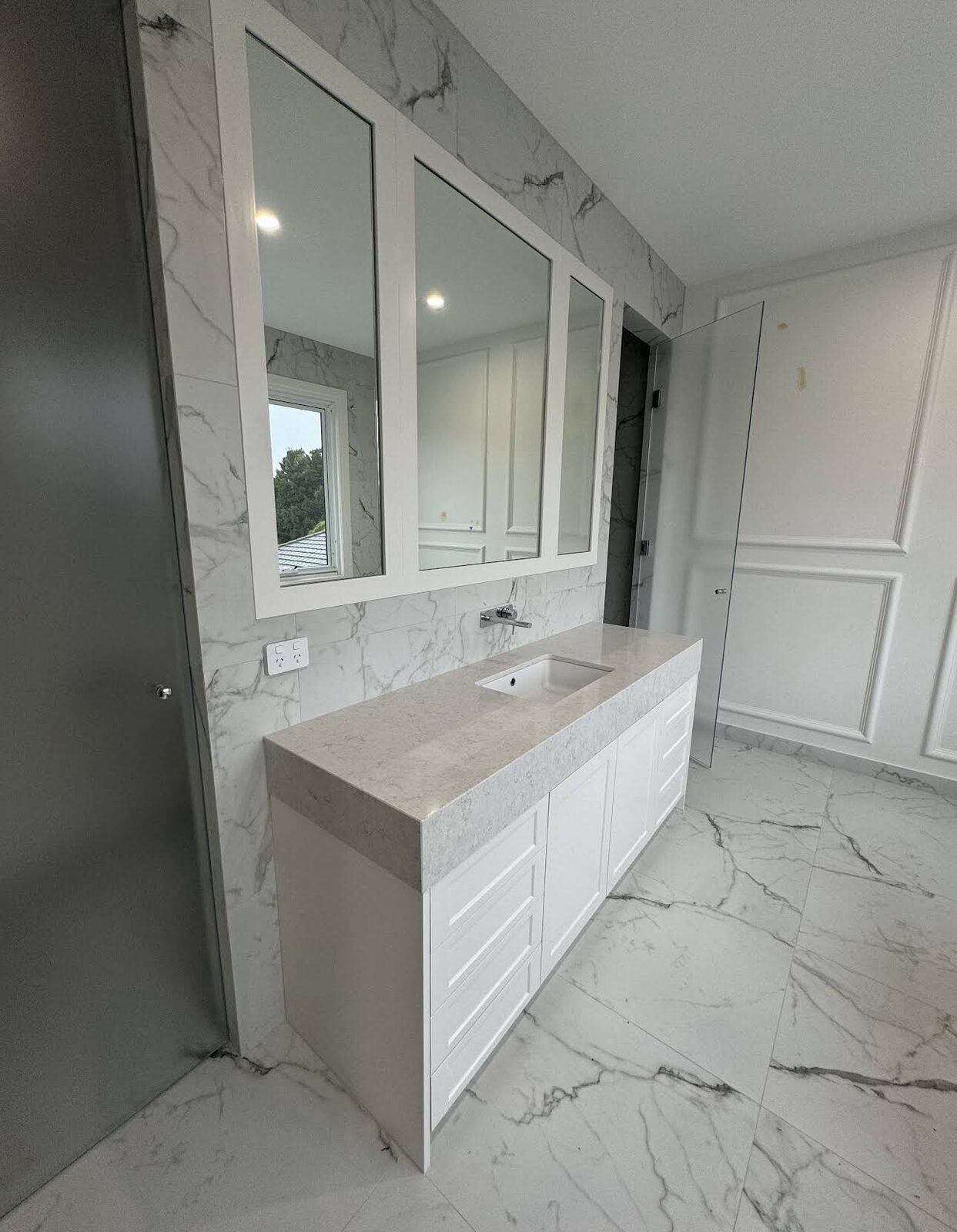 Marble-tiled bathroom and vanity after detailed cleaning